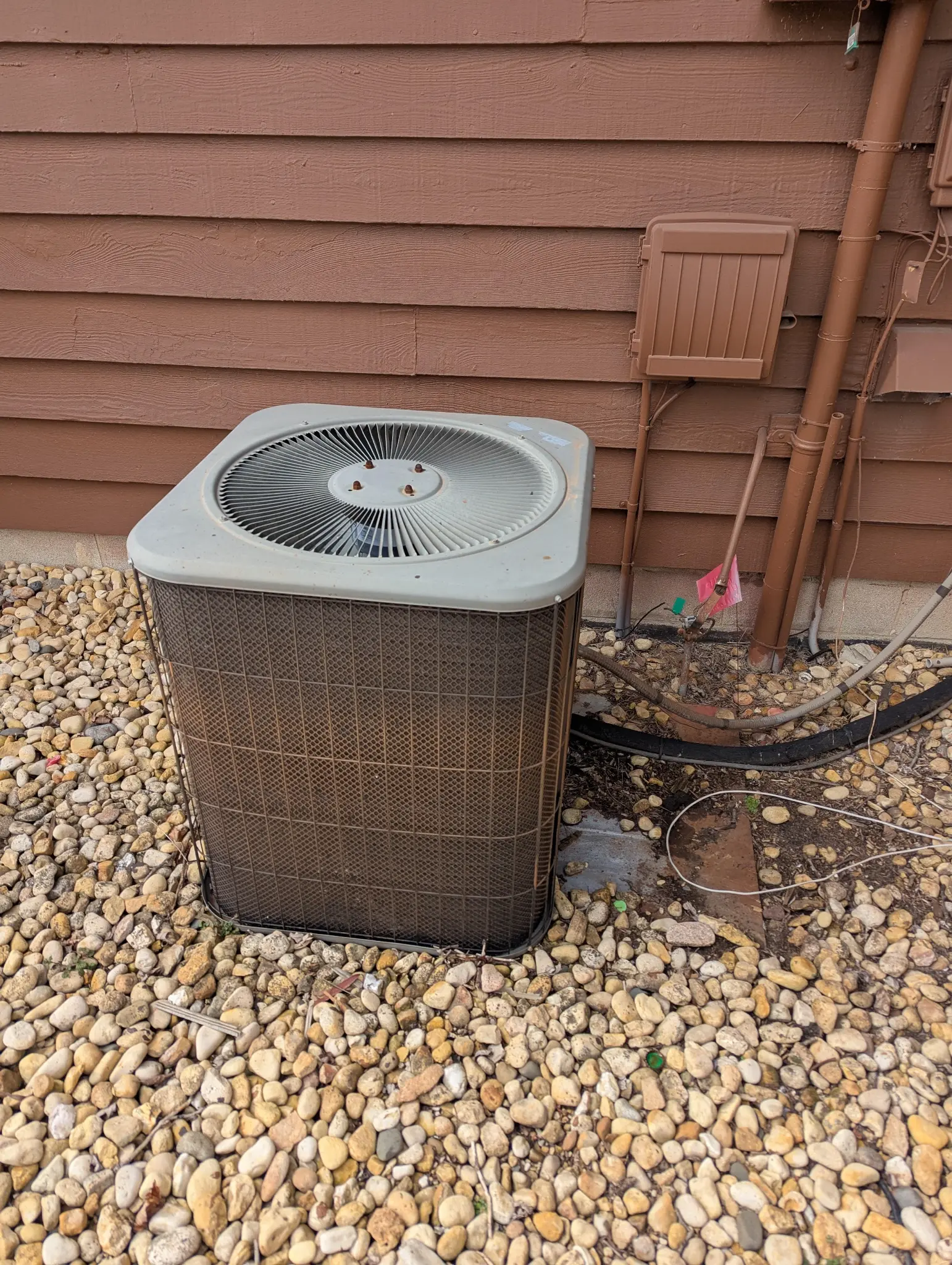 Outdoor HVAC condenser beside residential siding